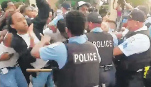  ?? NADER ISSA/SUN-TIMES ?? Police push back protesters near the scene where an officer fatally shot a man on July 14 in South Shore.