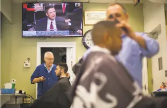  ?? Pablo Martinez Monsivais / Associated Press ?? Former FBI Director James Comey testifies before a Senate committee on live TV Thursday while barbers tend to patrons at Puglisi Hair Cuts in Washington.