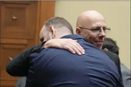  ?? PHOTOS BY MARIAM ZUHAIB — THE ASSOCIATED PRESS ?? Matthew Haynes, right, a founding owner of Club Q in Colorado Springs, Colo., hugs James Slaugh, a survivor of the shooting there, after a House Oversight Committee hearing on Capitol Hill in Washington on Wednesday.