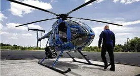  ?? FRED SQUILLANTE / COLUMBUS DISPATCH ?? Columbus Division of Police Lt. Jack Harris approaches one of the division’s McDonnell Douglas helicopter­s in 2020.