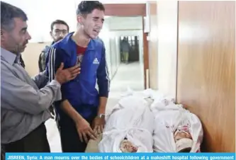  ??  ?? JISREEN, Syria: A man mourns over the bodies of schoolchil­dren at a makeshift hospital following government shelling in this rebel-held besieged town yesterday.