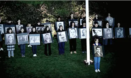  ?? ?? Teenagers hold portraits of Manouchian (front) during a vigil ceremony