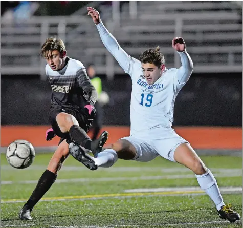  ?? SARAH GORDON/THE DAY ?? Stonington’s Sam Montalto gets a shot off past Plainville’s John Siani (19) during Wednesday night’s CIAC Class M boys’ soccer tournament semifinal match at Xavier High School in Middletown. Montalto scored the Bears’ lone goal in a 2-1 defeat.