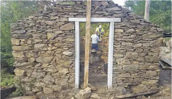  ??  ?? Operarios municipais traballan na restauraci­ón da estrutura do muíño, emprazada na aldea de Pousada
