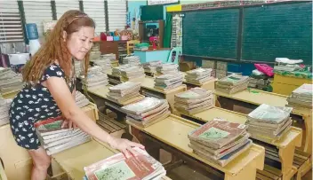  ?? SUNSTAR FOTO / ARNI ACLAO ?? BRIGHT AND EARLY . A day ahead of the opening of classes in public schools, stacks of textbooks are ready for this teacher’s pupils this school year.