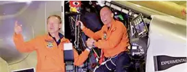  ?? — AP ?? Swiss pilots Andre Boschberg and Bertrand Piccard stand in the cockpit of their solarpower­ed plane after it touched down at Chongqing Jiangbei Internatio­nal Airport in south- western China’s Chongqing municipali­ty.