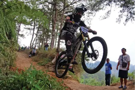  ?? Photo by Milo Brioso ?? THRILL. Rider Cris Manangan goes on air during a recent extreme bike challenge in Wangal, La Trinidad. Off road and downhill biking competitio­ns has become a trend in the Cordillera region recently.