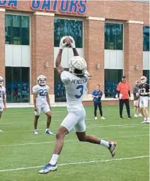  ?? ?? Florida receiver Xzavier Henderson hauls in a pass during a drill as the Gators kicked off their spring football camp Saturday in Gainesvill­e. It’s the second spring under coach Billy Napier.