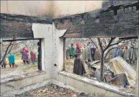  ?? WASEEM ANDRABI/HT PHOTO ?? Villagers gather near the house damaged during a gunfight between militants and government forces at Pinglish village of Tral, 40km south of Srinagar, on Monday.