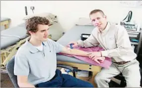  ?? Photo Courtesy BILL BALDWIN ?? Dan Kingsley, right, demonstrat­es soft tissue treatment on a willing participan­t.