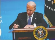  ?? DREW ANGERER / GETTY IMAGES ?? U.S. President Joe Biden signs an executive order related to American manufactur­ing and Buy American in the
White House complex on Monday.