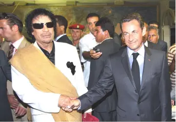  ??  ?? File photo shows Sarkozy shaking hands with Gaddafi (left) upon his arrival for an offcial visit to Libyain Tripoli. — AFP photo