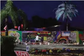  ?? —AFP ?? ORLANDO, Florida: John Hough visits the memorial setup outside the Pulse gay nightclub yesterday as he remembers the victims of a mass shooting at the club one year ago.