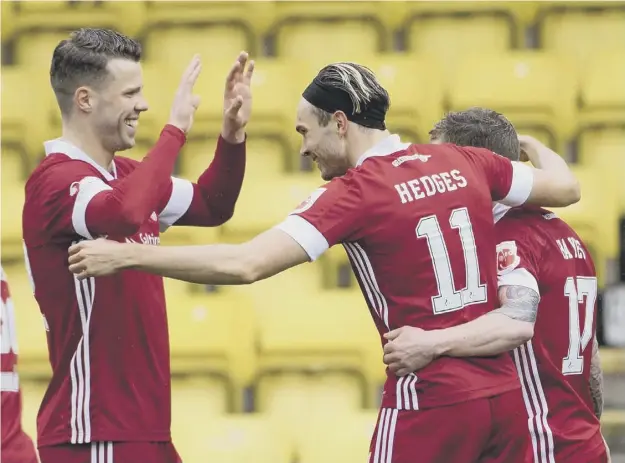  ??  ?? 0 Ryan Hedges celebrates with Jonny Hayes and Florian Kamberi, left, after putting Aberdeen 2-0 ahead at Livingston on Saturday