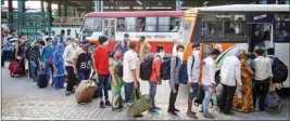  ??  ?? Migrants travelling from Surat via a special train board a bus to reach their native places, during the ongoing COVID-19 nationwide lockdown, in Prayagraj, on Monday