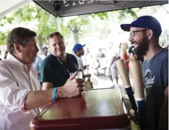  ?? MELISSA RENWICK PHOTOS/TORONTO STAR ?? Mayor John Tory speaks with Left Field Brewery co-owner Mark Murphy, right, at Toronto’s Festival of Beer in Bandshell Park on Sunday. The mayor said government rules on beer consumptio­n are “ancient.”