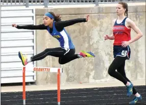  ?? Photo by Mike Eckels ?? Decatur’s Desi Meek sails over a hurdle in the 100-meter hurdles. Meek captured first place in both the 100- and 300-meter hurdles to give the Decatur girls a fourthplac­e finish in the meet.