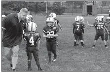  ?? AP/RALPH RUSSO ?? John Galligan (left) directs players during a Rookie Tackle youth football game in Islip, N.Y. USA Football has introduced the program called Rookie Tackle football which is played on a 40-yard field with as few as six players.