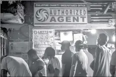  ?? (Ian Paul Cordero photo) ?? Bettors form long line to buy lotto tickets.