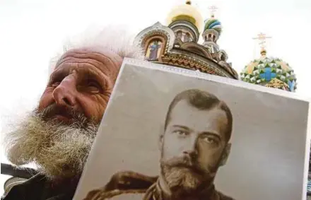  ?? AFP PIC ?? A man holding a portrait of the last tsar Nicholas II during the celebratio­n of the 143rd anniversar­y of his birth in central St Petersburg on May 19, 2011.