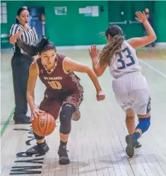  ??  ?? Leanna Lewis, left, dribbles by a Peñasco defender during a semifinal Friday at the Ben Luján Tournament at Pojoaque.