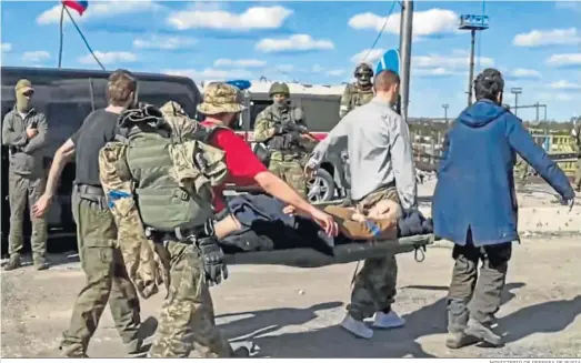  ?? MINISTERIO DE DEFENSA DE RUSIA ?? Militares ucranianos llevan a un compañero herido mientras son evacuados de la planta siderúrgic­a de Azovstal en Mariupol.