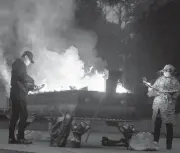  ?? NG HAN GUAN/AP ?? Residents burn paper offerings late Friday in Wuhan, China, for a relative who died from COVID-19.