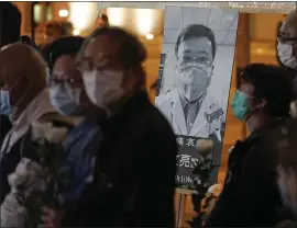  ?? KIN CHEUNG — THE ASSOCIATED PRESS ?? People wearing masks attend a vigil for the late Chinese doctor Li Wenliang in Hong Kong on Friday. Li had been reprimande­d by police after warning about China’s new coronaviru­s.