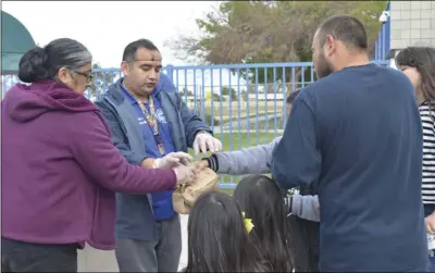  ?? JULIO MORALES PHOTO ?? El Centro Elementary School District food services employees on Tuesday handed out paper bags containing breakfast and lunch for students at Martin Luther King Jr. Elementary School as a result of recent countywide school closures.