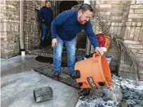  ?? Yi-Chin Lee / Staff photograph­er ?? Jacob Chapa dumps water pumped out of his mother-in-law’s house Tuesday after her pipes had burst.