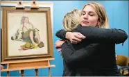  ?? MATT ROURKE/AP PHOTO ?? Emily Murta, right, and Kaitlin Grant embrace during a news conference in Philadelph­ia regarding the newly recovered Norman Rockwell painting.