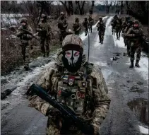  ?? YASUYOSHI CHIBA — AFP/GETTY IMAGES ?? Ukrainian servicemen walk on the road toward their base near the frontline in the Donetsk region on Feb. 4, 2023, amid the Russian invasion of Ukraine.