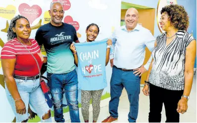  ?? ?? Rickayla Miller (centre) poses happily with parents Clive Miller (second left) and Nadine Austin ( left). With them are Christophe­r Zacca, chairman of the Sagicor Foundation, and Diane Edwards, chairman, Chain of Hope.