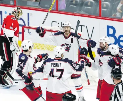  ?? THE CANADIAN PRESS/FRED CHARTRAND ?? Sens goalie Mike Condon looks down as Columbus celebrates after Cam Atkinson scored in the third period.