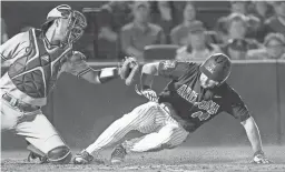  ??  ?? Arizona’s Tate Soderstrom (44) tags and scores on a sacrifice fly ahead of the tag from Arizona State catcher Lyle Lin during the fourth inning of Thursday night’s game at Hi Corbett Field in Tucson. Arizona won the first of the three-game series 6-4.