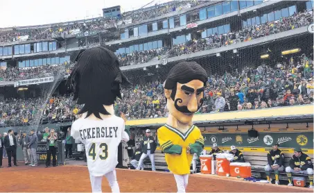  ?? Ben Margot / Associated Press ?? The A’s Dennis Eckersley and Rollie Fingers mascots entertain the big crowd before Tuesday’s game against the White Sox.