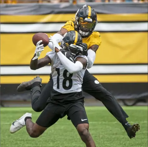  ?? Emily Matthews/Post-Gazette photos ?? Wide receiver Diontae Johnson, foreground, catches this pass despite the presence of Justin Layne Saturday in practice at Heinz Field.