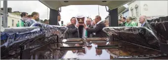  ??  ?? Former Castleisla­nd AFC juvenile players Mike Brosnan and Paul Geaney leading the pall-bearers as they bring the remains of their mentor to Tangney’s hearse. Photo by John Reidy