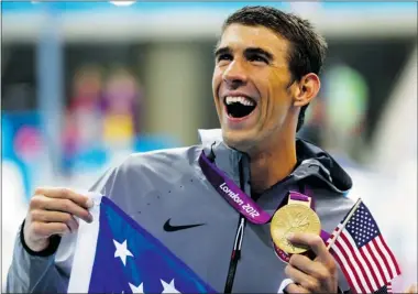  ?? Reuters ?? U.S. swimmer Michael Phelps holds up the gold medal he shared in the 4x200m freestyle relay at the Olympics in London
on Tuesday. It was the 19th Olympic medal of his career, making him the most decorated Olympian of all time.