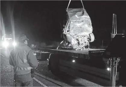  ??  ?? La grúa retira los restos del coche siniestrad­o en presencia de un agente de la Policía Foral.