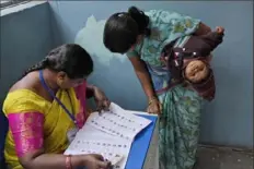  ?? Mahesh Kumar A./Associated Press ?? A woman checks for her name before casting her vote at a polling station during the Telangana state assembly elections in Hyderabad, India, on Nov. 30.