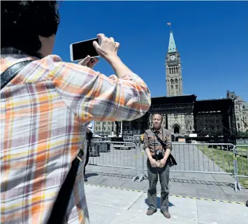  ?? SEAN KILPATRICK/THE CANADIAN PRESS ?? Tourists visit Parliament Hill in Ottawa last week as preparatio­ns for Canada Day are underway. Be alert but not alarmed, police are urging Canadians who will attend Canada 150 celebratio­ns next month.