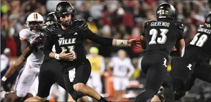  ?? (AP PHOTO/TIMOTHY D. EASLEY) ?? Louisville quarterbac­k Jack Plummer (13) hands off the ball to running back Isaac Guerendo (23) during the second half of an NCAA college football game against Virginia in Louisville, Ky., Thursday, Nov. 9, 2023.