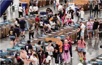  ?? Brett Coomer/Staff photograph­er ?? People browse through the dogs up for adoption at the Convention Center. At least 14 shelters and rescue organizati­ons — some of them critically overcrowde­d — brought animals to the event.