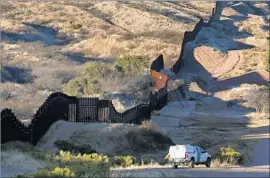  ?? Carolyn Cole Los Angeles Times ?? BORDER FENCE snakes along the U.S.-Mexico line near Nogales, Ariz. There had been speculatio­n about Cemex’s possible involvemen­t in Trump’s project.