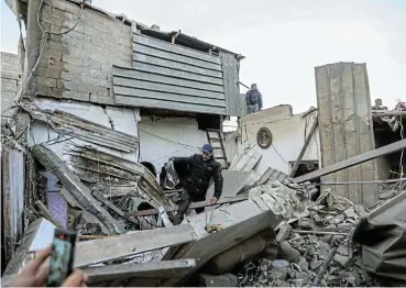  ?? /Reuters ?? Debris: People inspect damage to their homes after Israeli air strikes on Monday in Rafah, Gaza. The Gaza health ministry says 67 Palestinia­ns were killed overnight and the number could rise as rescue operations are under way.