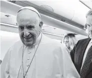  ?? THE ASSOCIATED PRESS ?? Pope Francis greets journalist­s on board the flight to Bogota, Colombia, Wednesday.