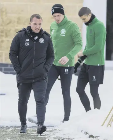  ??  ?? 0 Brendan Rodgers steps out at a snowy Lennoxtown ahead of yesterday’s training session.