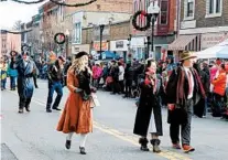  ?? JAY JONES/FOR THE CHICAGO TRIBUNE ?? Locals dressed as characters from “It’s a Wonderful Life” greet the crowd as they walk through downtown Seneca Falls in 2017’s parade.