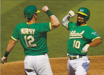  ?? ERIC RISBERG — THE ASSOCIATED PRESS ?? The A’s Marcus Semien (10) celebrates after hitting a two-run home run that scored Sean Murphy (12) against the White Sox on Tuesday.